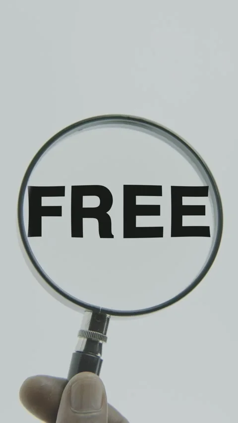 Free text or word highlighted by a magnifying glass in a hand on a white Stock Footage 303449719