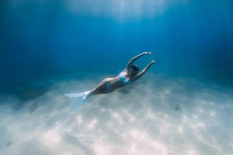 Freediver on the deep over sandy bottom with white bikini and fins. Attractiv Stock Photos