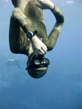 Freediver equalizing pressure while moving down Stock Photos
