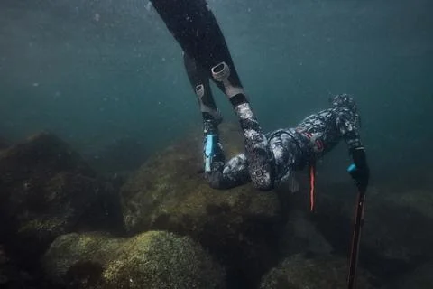 Freediver exploring underwater rocks Stock Photos