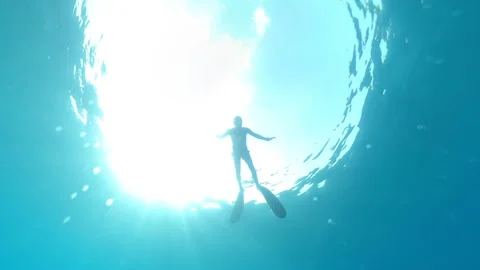 A freediver on the sea surface in a beam of light Stock Footage 199977715