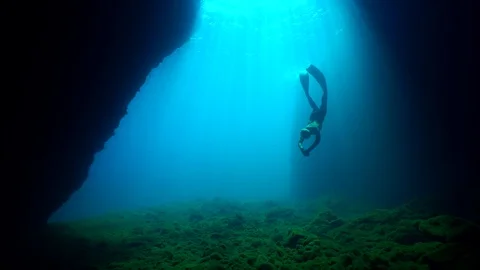 Freediver swimming in a cave 스톡 동영상 127954093