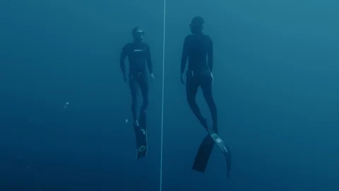 Freedivers training in deep blue ocean Stockbeeldmateriaal 117026213