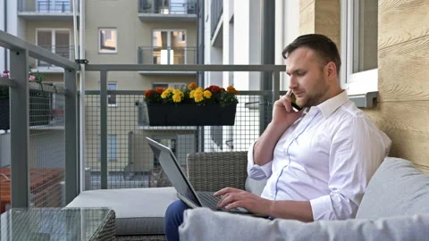 Freelance and remote work. The man works comfortably on his balcony. He uses a Stock Footage 135502553