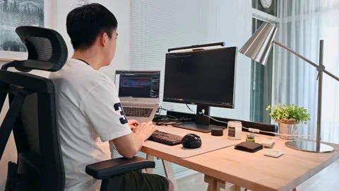 Freelance asian man working and coding with computer on wooden desk in modern Stock Footage 162328080