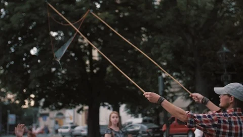 A freelance clown blowing hundreds of tiny, small and big bubbles at outdoor Video stock 104205614