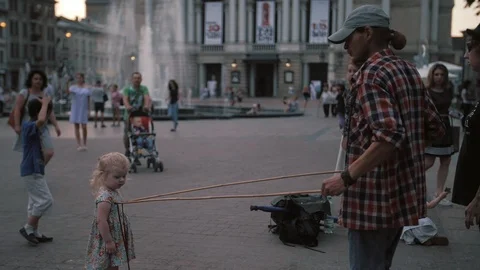 A freelance clown blowing hundreds of tiny, small and big bubbles at outdoor Stock Footage 104205643