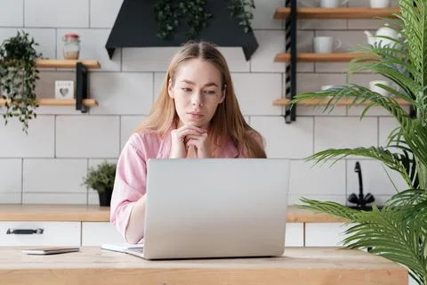Freelance employee working at computer, thinking over ideas, watching video Stock Photos