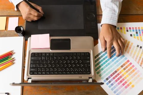 Freelance graphic designer using digital tablet, computer, man working with.. Foto stock
