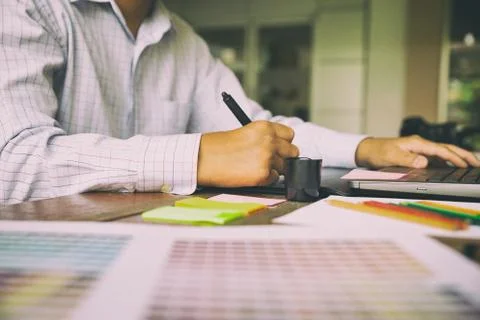 Freelance graphic designer using digital tablet, computer, man working with.. Stock-Fotos