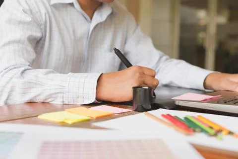 Freelance graphic designer using digital tablet, computer, man working with.. Foto stock