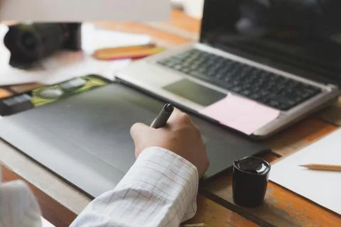 Freelance graphic designer using digital tablet, computer, man working with.. Foto stock