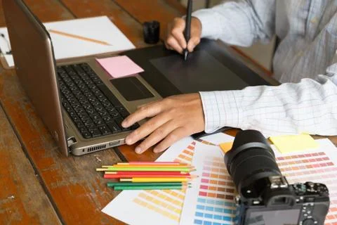 Freelance graphic designer using digital tablet, computer, man working with.. Foto stock