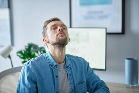 Freelance male software developer or IT support looking up with closed eyes Foto stock