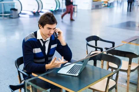 Freelance man using mobile phone and laptop pc Stock Photos
