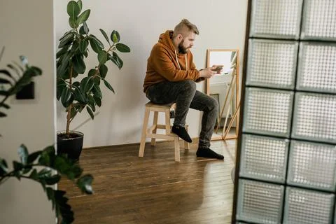 Freelance man using mobile phone checking social media network feed or message 스톡 사진
