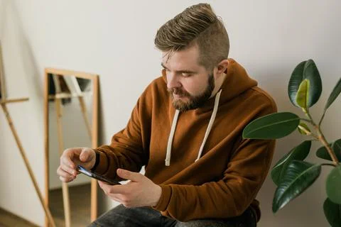 Freelance man using mobile phone checking social media network feed or message 写真素材