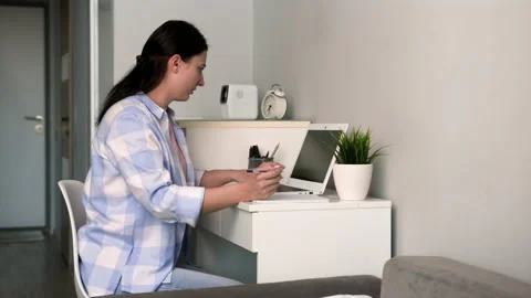A freelance mom is distracted from her work when her daughter comes up to her. Stock Footage 239377291