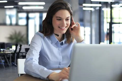 Freelance operator talking with headsets and consulting clients from office. Stock Photos