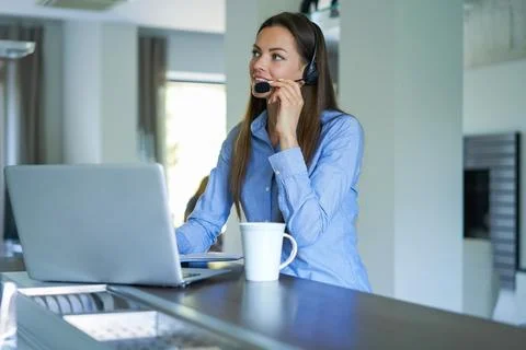 Freelance operator talking with headsets and consulting clients from home off Stock Photos