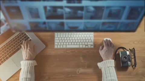 Freelance photographer at work. Close-up top view of man working on laptop while Stock Footage 72505452