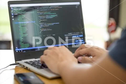 Freelance programmer or developer working at home and typing source code with Stock Photos