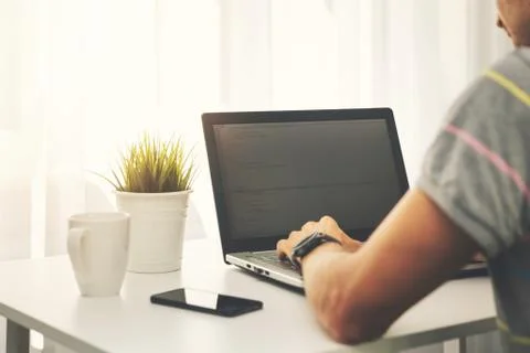Freelance programmer programming new website on laptop at home Stock Photos