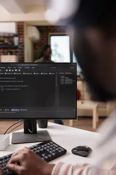 Freelance programmer working remote writing code for software on pc using Stock Photos