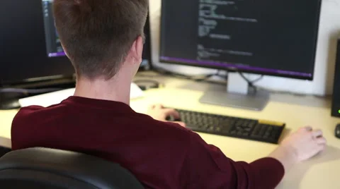 Freelance programmer writes a program while sitting at the computer Stock Footage 63421264