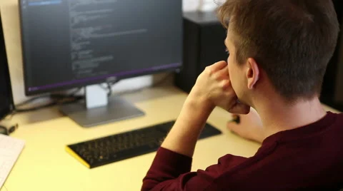 Freelance programmer writes a program while sitting at the computer Vidéo 63421273