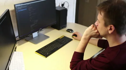 Freelance programmer writes a program while sitting at the computer Vidéo 63421282