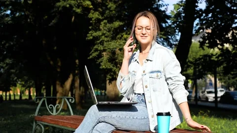 Freelance, remote work, outdoor distance education. Young woman calling phone Stock Footage 164451797