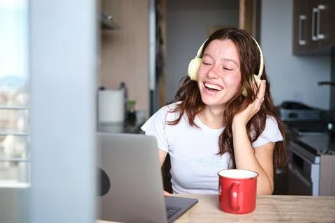 Freelance worker using laptop and headphones at home Stock Photos