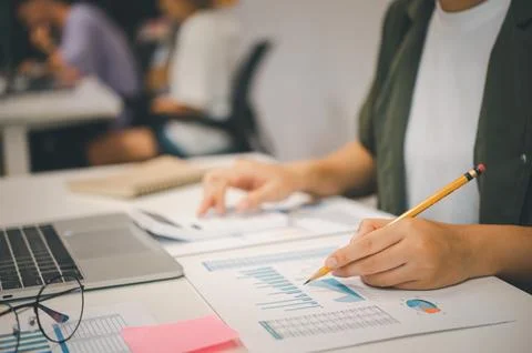 Freelance worker working on documents with graphs. and information about fi.. Stock Photos