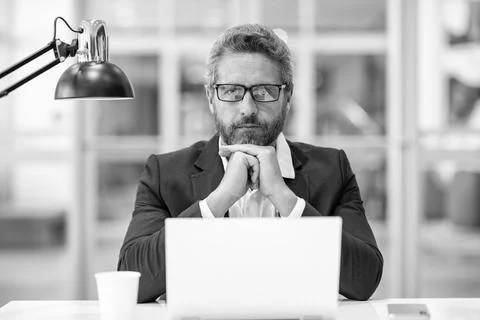 Freelance working online. Serious man using laptop in office. Business Stock Photos