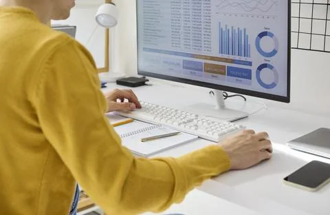Freelancer analyzing finance data at home office desktop with charts and graphs Foto stock