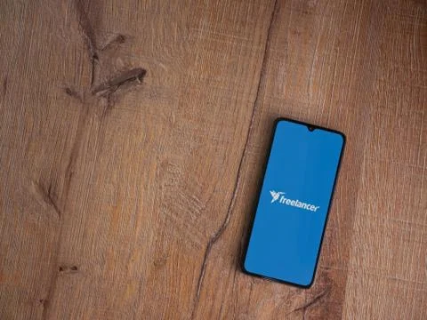 Freelancer app launch screen with logo on the display of a black mobile smart Stock Photos