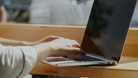 Freelancer arms working on computer at the window sill Stock Footage 112988402