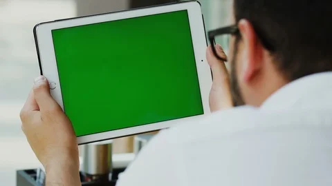 Freelancer with black glasses looking to the chromakey screen of digital tablet Stock Footage 112990554