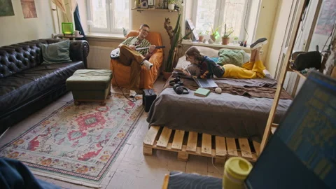 Freelancer Coding on Computer and Being Distracted by Roommates in Background Video stock 334798009