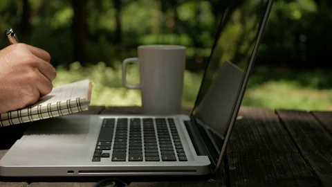 Freelancer designer looking ideas on laptop and writing on notebook Stock Footage 70558362