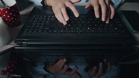 Freelancer developer student in shirt is typing on a laptop with a phone next 스톡 동영상 344915399