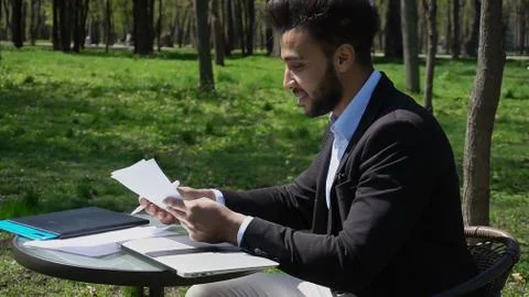 Freelancer doing paper work and talking on phone. Stock Photos