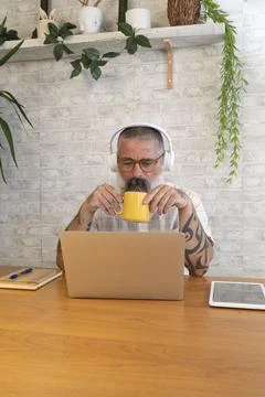 Freelancer drinking coffee and working from home office using laptop Stock-Fotos