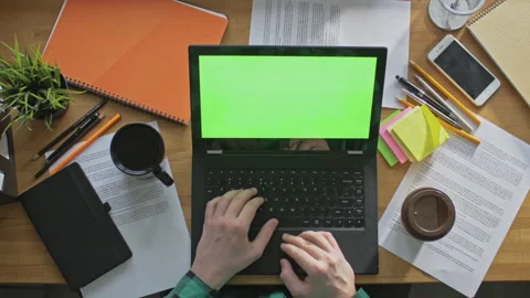 Freelancer drinking coffee, working on laptop with green screen indoors Stock Footage 142866957