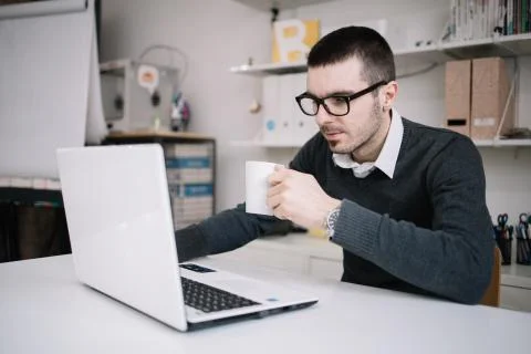 Freelancer drinking tea and working in office Stock Photos