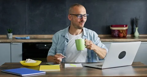 Freelancer eating and drinking hot beverage holds meeting Video stock 229840196