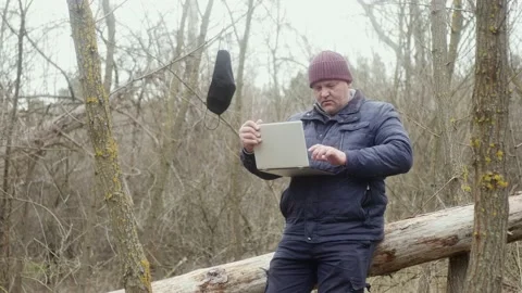 Freelancer in the forest typing with his left hand on a laptop while sitting Vídeos de archivo 170983474