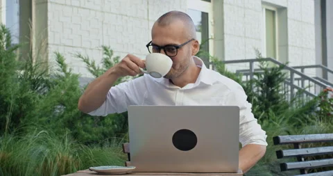 Freelancer in glasses aggressively types messages on laptop Stockbeeldmateriaal 253627221