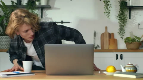 Freelancer is going to start working, Guy is coming to kitchen and sits down Stock Footage 146360124